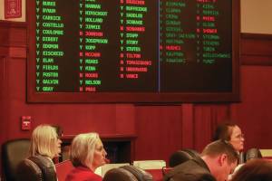 Rep. Andi Story (D-Juneau), Rep. Rebecca Himschoot (I-Sitka), and Rep. Sarah Vance (R-Homer) watch the vote tally during a veto override joint session on an education bill Tuesday. (Jasz Garrett / Juneau Empire)