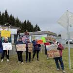 Demonstrators stand on the corner of Pioneer Avenue and Svedlund Street in Homer, Alaska on Friday, May 30. They hoped to catch Senator Sullivans attention as he drove by to attend a private meeting at the Homer Senior Citizens Center.