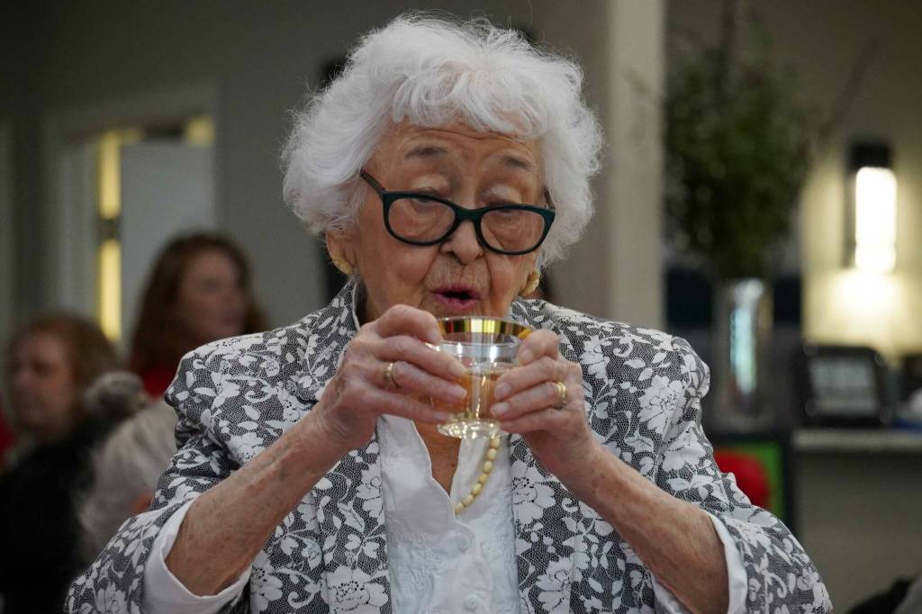 Hanna Stormo sips a glass of pinot grigio during her 102nd birthday party at Aspen Creek Senior Living in Soldotna, Alaska, on Friday, May 30, 2025. (Jake Dye/Peninsula Clarion)