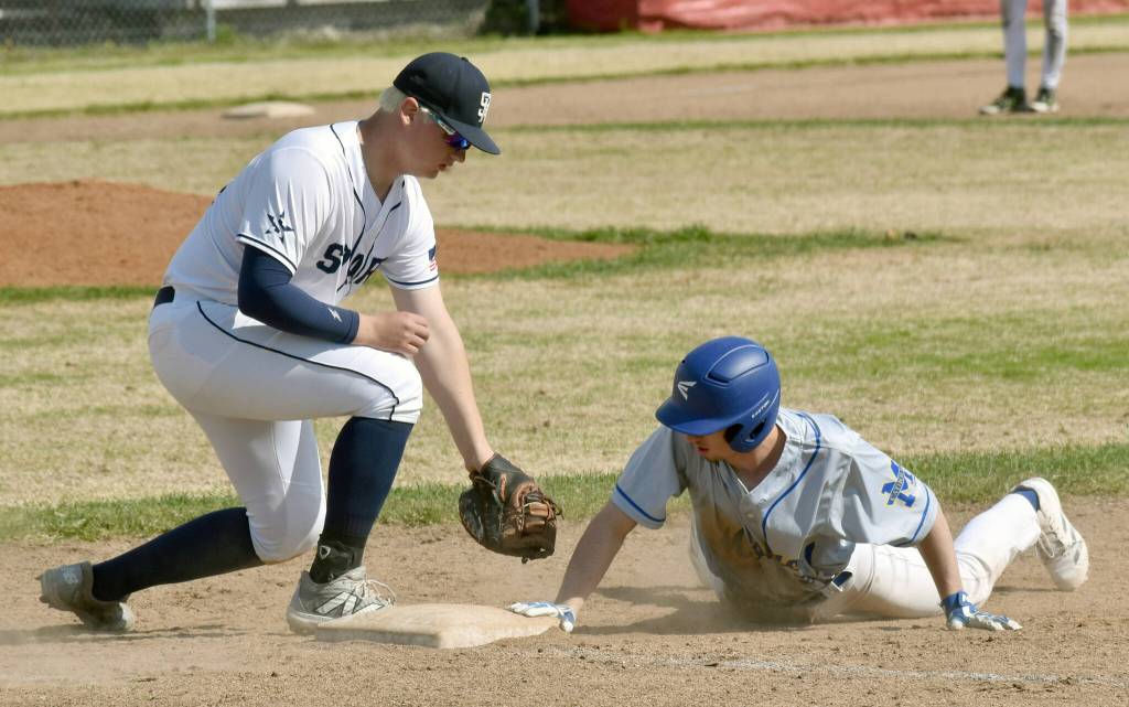 Monroe Catholics Charlie Menard slides in safely in front of Soldotnas Jayden Stuyvesant at the Division II state baseball tournament at Coral Seymour Memorial Park in Kenai, Alaska, on Friday, June 6, 2025. (Photo by Jeff Helminiak/Peninsula Clarion)