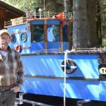 Larry Bernbeck poses for a photo with Tugster on Thursday, June 5, 2025 in Homer, Alaska. (Chloe Pleznac/Homer News)
