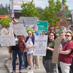 People carrying flags and signs line the Sterling Highway for a "No Kings" protest in Soldotna, Alaska, on Saturday, June 14, 2025. (Jake Dye/Peninsula Clarion)