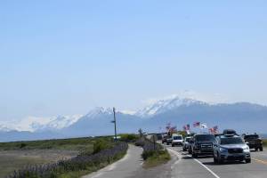 Cars and trucks adorned with flags drive down the Homer Spit Road on Saturday, June 14, 2025 in Homer, Alaska. The processional was in honor of Flag Day and the 250th anniversary of the U.S. Army being formed. (Chloe Pleznac/Homer News)