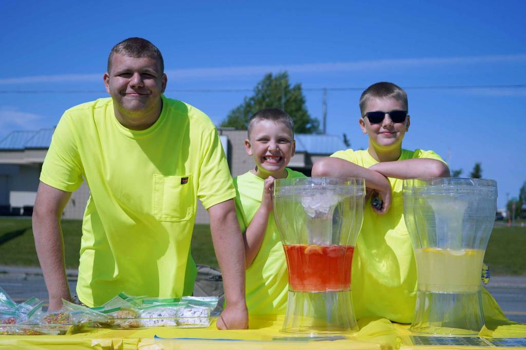 Brayden, Jackson and Bradley Gage staff the Lighting Lemon lemonade stand in Kenai, Alaska, on Saturday, June 14, 2025. (Jake Dye/Peninsula Clarion)