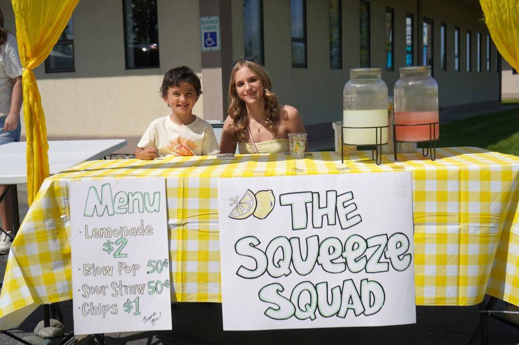 Brooklyn Coleman, right, staffs The Squeeze Squad lemonade stand during Lemonade Day in Soldotna, Alaska, on Saturday, June 14, 2025. (Jake Dye/Peninsula Clarion)