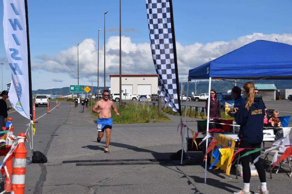 Michael Shearer crosses the finish line near Lands End Resort, taking first place in the mens category for the Cosmic Hamlet Half Marathon on Saturday, June 28, 2025, in Homer, Alaska. (Delcenia Cosman/Homer News)