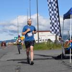 Silas Firth, competing in the Cosmic Hamlet Half Marathon, crosses the finish line near Lands End Resort on the Homer Spit on Saturday, June 28, 2025, in Homer, Alaska. (Delcenia Cosman/Homer News)