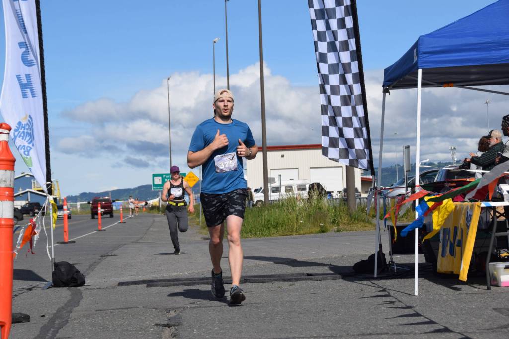 Silas Firth, competing in the Cosmic Hamlet Half Marathon, crosses the finish line near Lands End Resort on the Homer Spit on Saturday, June 28, 2025, in Homer, Alaska. (Delcenia Cosman/Homer News)