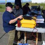 South Peninsula Amateur Radio Club member Toby Reich and club president Rick Baird operate a ham radio during a nationwide contest on Saturday, June 28, 2025, on the Homer Spit in Homer, Alaska. (Delcenia Cosman/Homer News)
