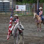Haylee Overson and Adeline Mills present the American and Alaska flags on Sunday, July 6, 2025, at the Kenai Peninsula Fairgrounds in Ninilchik, Alaska. (Chloe Pleznac/Homer News)