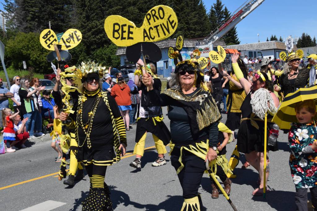 Mavis Muller (left) leads community members gathered in the Bee the Change group display down Pioneer Avenue during the Fourth of July parade on Friday, July 4, 2025, in Homer, Alaska. (Delcenia Cosman/Homer News)