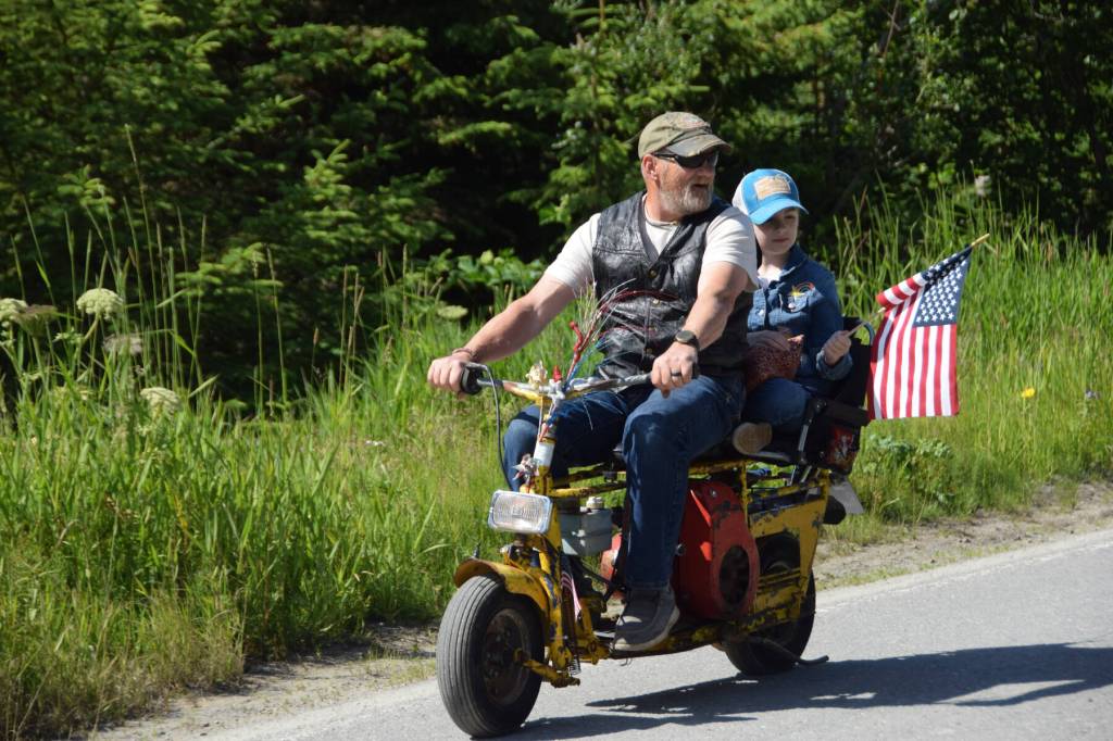 A community member drives a motorbike down Milo Fritz Avenue during the Fourth of July parade on Friday, July 4, 2025, in Anchor Point, Alaska. (Delcenia Cosman/Homer News)