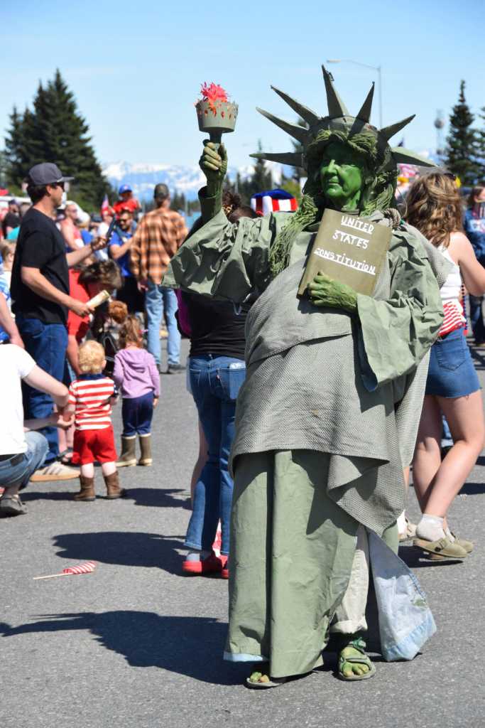 Claire ODonnell marches down Pioneer Avenue as the Statue of Liberty during the Fourth of July parade on Friday, July 4, 2025, in Homer, Alaska. (Delcenia Cosman/Homer News)