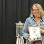 Sharlene Cline holds up her Artist of the Year award at Homer Council on the Arts annual Community Arts Award Ceremony on Saturday, July 19, 2025, in Homer, Alaska. (Delcenia Cosman/Homer News)