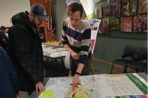 Attendees of the open house event for the draft 2035 comprehensive plan evaluate potential land use maps on Tuesday, Feb. 11, 2025, at the Alaska Maritime National Wildlife Refuge Visitor Center in Homer, Alaska. (Delcenia Cosman/Homer News)