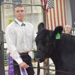 Jacob Merritt displays the Overall Grand Champion Beef at the Junior Market Livestock Auction at the Kenai Peninsula District 4-H Agriculture Expo on Saturday, July 27, 2025, at the Soldotna Regional Sports Complex in Soldotna, Alaska. (Photo by Jeff Helminiak/Peninsula Clarion)