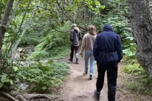 Yarrow Hinnant, Elizabeth Pileckas and Kim McNett walk the Pratt Museum Trail on Friday, July 25. (Chloe Pleznac/Homer News)