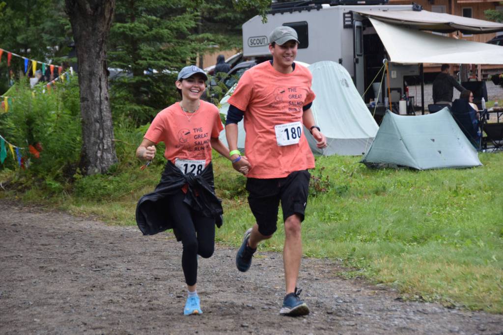 Grace Angivran Moore-Anderson and Austin Anderson race to the finish line, hand in hand, on Saturday during the 3rd annual Great Salmon Run. (Chloe Pleznac/Homer News)