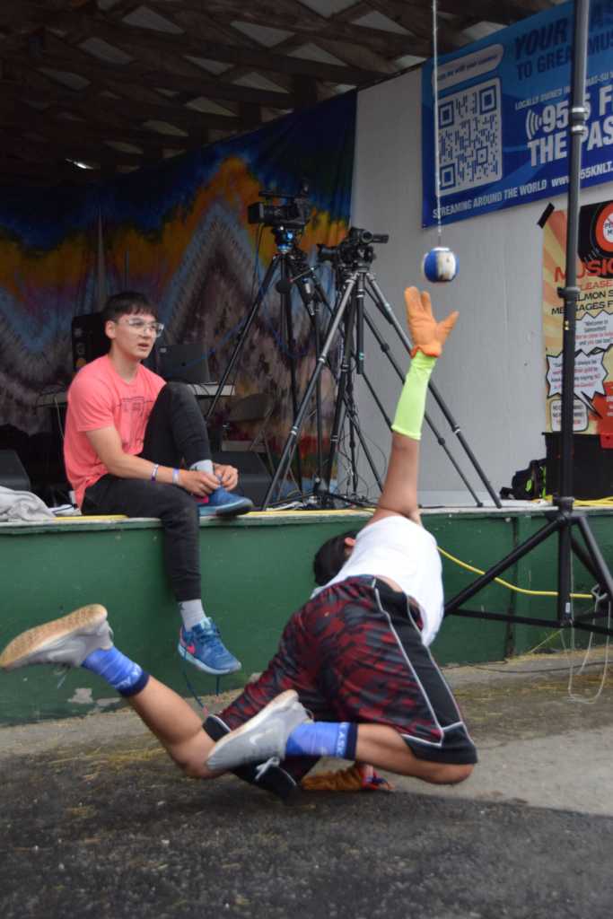 Trevor Edwards performs the one hand reach during a Native Youth Olympics demonstration at the Inlet Stage on Saturday, Aug. 2, 2025, at the Kenai Peninsula Fairgrounds in Ninilchik, Alaska. (Delcenia Cosman/Homer News)