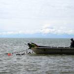 Gary Hollier, right, watches as a setnet is pulled into a boat in the waters of Cook Inlet in Kalifornsky, Alaska, on Wednesday, Aug. 6, 2025. (Jake Dye/Peninsula Clarion)