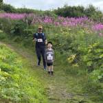 Kyle Settles and Jack Settles run along the trail at Eveline State Recreation Site on Saturday, Aug. 9, 2025, during the inaugeral 5K hosted by Kachemak Bay Running Club. (Photo courtesy of Michael Murray)