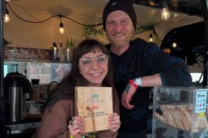 Fika co-owners Sierra Moskios-Schlieman and Tyler Moskios-Schlieman pose for a photograph with their Taste of Homer plaque at the 2025 HarborFest in June. (Photo courtesy of Fika Coffee Roasters)
