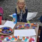Rosie Mahowald mans the booth she and her brother shared at the Homer Farmers Market on Kids Vending Day on Wednesday, Aug. 13, 2025, in Homer, Alaska. (Delcenia Cosman/Homer News)