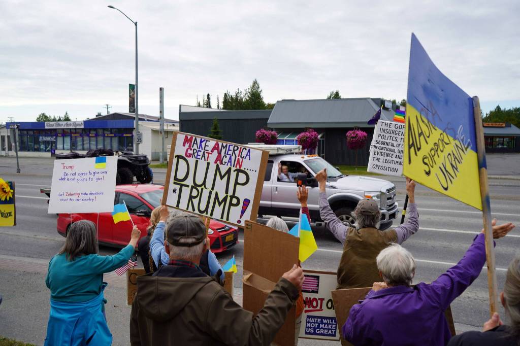 Protesters in support of Ukraine wave at passersby on the Sterling Highway in Soldotna, Alaska, on Friday, Aug. 15, 2025. (Jake Dye/Peninsula Clarion)