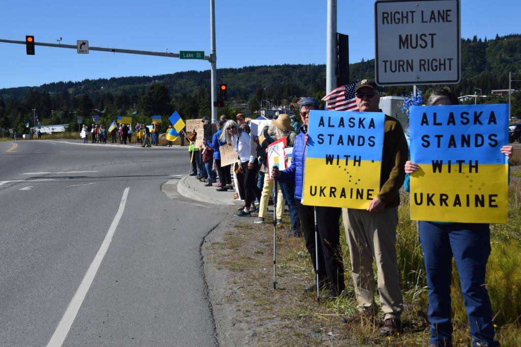 Protesters hold up signs expressing support for Ukraine on Friday, Aug. 15, 2025, at the intersection of Lake Street and the Sterling Highway in Homer, Alaska. (Delcenia Cosman/Homer News)