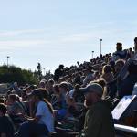 A large crowd watches the home game on Friday, August 22. It spanned all sets of bleachers and stretched across the sunny, grassy areas too. (Chloe Pleznac/Homer News)