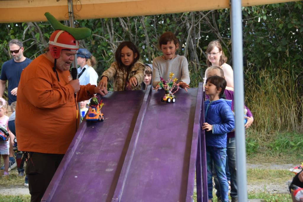 Volunteer Joey Lothian (left) returns as emcee and race operator during the annual Zucchini Festival on Saturday, Aug. 23, 2025, at the Homer Farmers Market in Homer, Alaska. (Delcenia Cosman/Homer News)