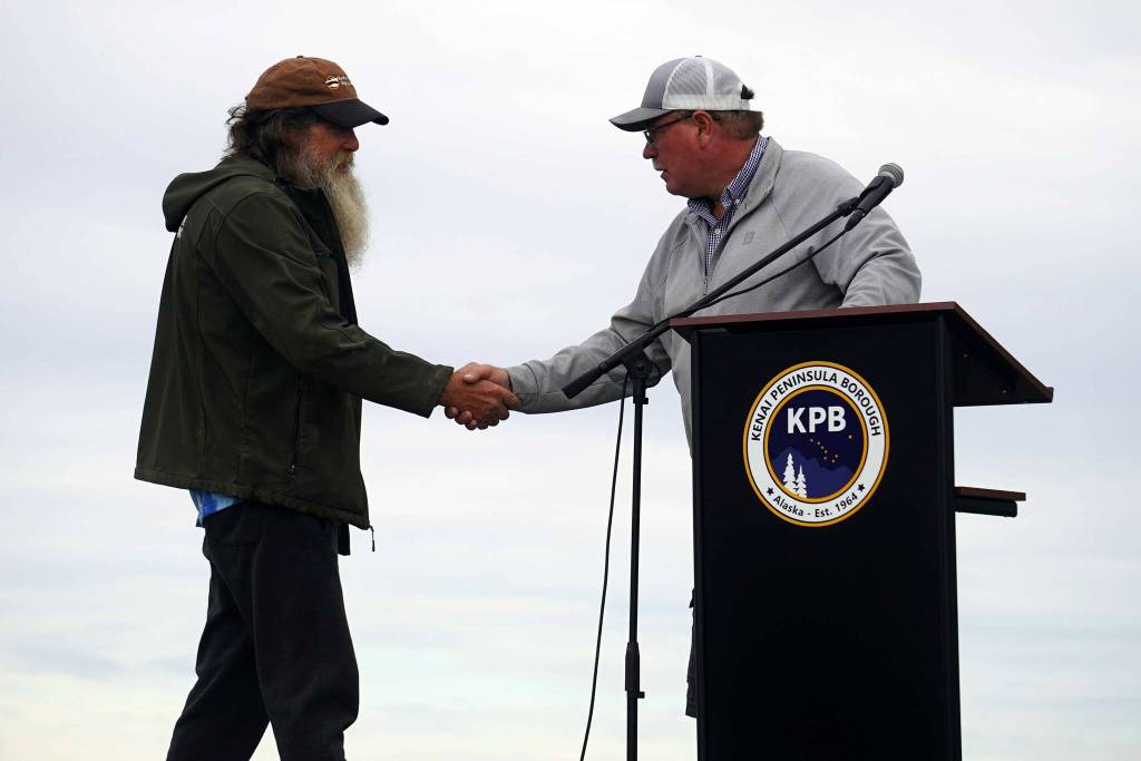 Bill Sleasman is greeted by Kenai Mayor Brian Gabriel after receiving the Outstanding Support for Commercial Fishing Award during the 2025 Industry Appreciation Day at the Kenai Softball Greenstrip in Kenai, Alaska, on Saturday, Aug. 23, 2025. (Jake Dye/Peninsula Clarion)