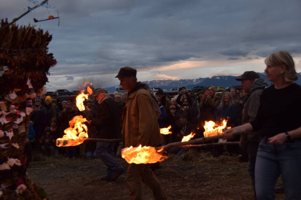 Torch bearers prepare to light the basket on Sunday, Sept. 7, 2025, at Mariner Park in Homer, Alaska. (Chloe Pleznac/Homer News)