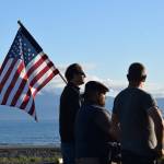 A man holds an American flag at a vigil for Charlie Kirk on Wednesday, Sept. 17, 2025, at Mariner Park on the Homer Spit in Homer, Alaska. (Chloe Pleznac/Homer News)