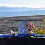 A table, honoring Charlie Kirk, rests on the Homer beach at Mariner Park on Wednesday, Sept. 17, 2025. Copies of pocket constitutions rest beside flowers and an image of Kirk, who was shot and killed in Utah on Sept. 10. (Chloe Pleznac/Homer News)