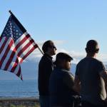 A man holds an American flag at a vigil for Charlie Kirk on Wednesday, Sept. 17, 2025 at Mariner Park on the Homer Spit in Homer, Alaska. (Chloe Pleznac/Homer News)