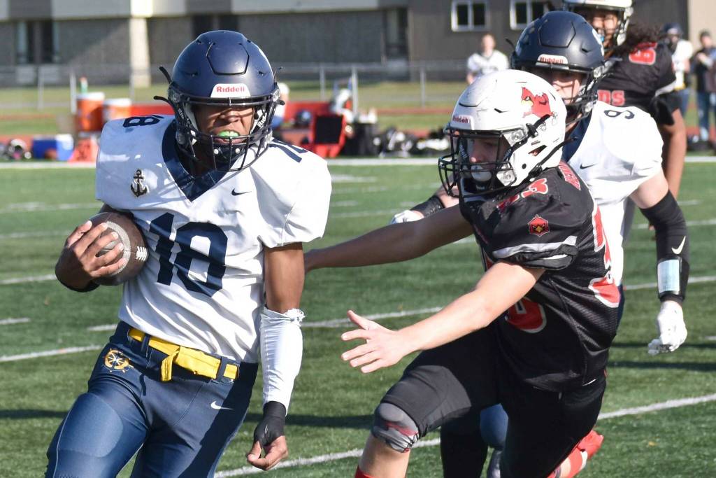 Homer's Nik Macauly runs past Kenai Central's Carson Cramer on Saturday, Sept. 27, 2025, at Ed Hollier Field at Kenai Central High School in Kenai, Alaska. (Photo by Jeff Helminiak/Peninsula Clarion)