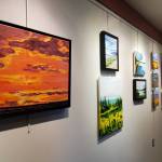 Artwork from a summer painting workshop is on display on the gallery wall in Kachemak Bay Campus's Pioneer Hall on Saturday, Oct. 18, 2025, in Homer, Alaska. (Delcenia Cosman/Homer News)
