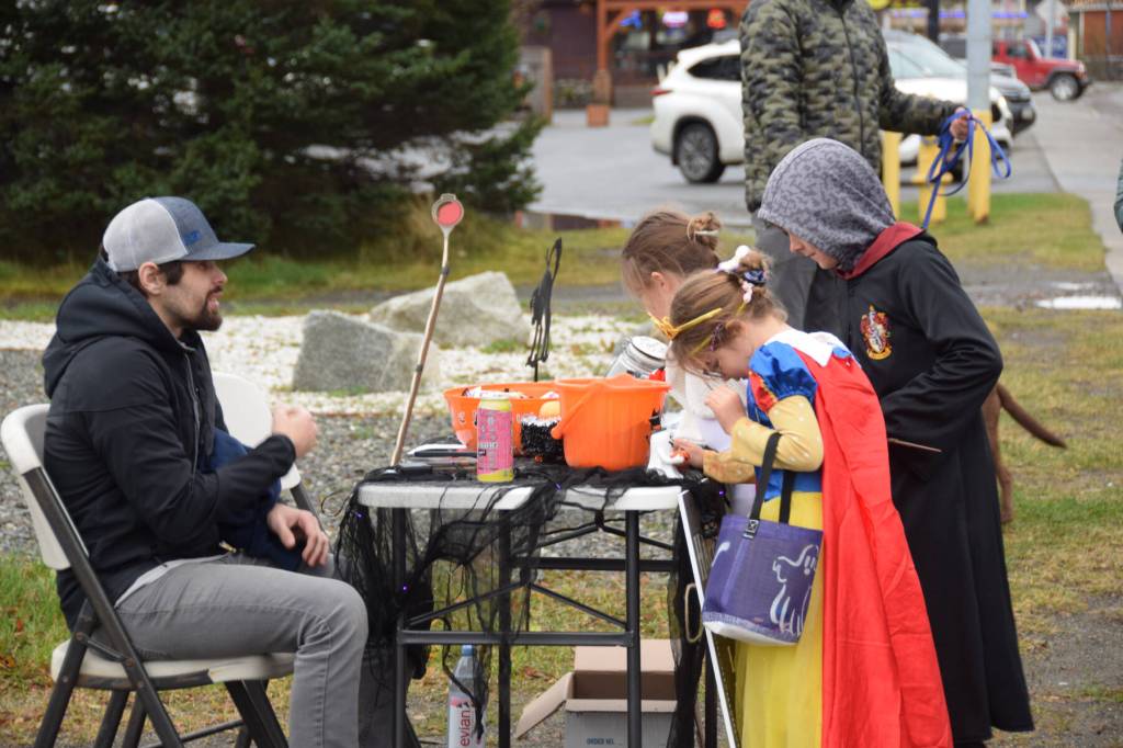 Kids pick up candy from participating businesses during Pioneer Avenue Trick or Treat on Friday, Oct. 31, 2025, in Homer, Alaska. (Delcenia Cosman/Homer News)