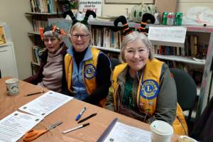Lady Lions Marcia Lowe, Julie Small and Linda Petkash with the Homer Lions Club conduct sign-ups for Thanksgiving food boxes at the Homer United Methodist Church in Homer, Alaska. More than 230 families requested food boxes this year, an increase from 166 boxes in 2024. Photo provided by Deb Schmidt