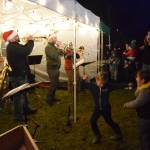 Kids dance to music played by the KP Brass Band during the holiday tree lighting ceremony on Thursday, Dec. 4, 2025, at the Homer Chamber of Commerce in Homer, Alaska. (Delcenia Cosman/Homer News)