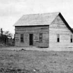 Image from the Rasmuson Library historical archives at the University of Alaska Fairbanks
Kenai Station superintendent Hans P. Nielsen finished construction of his quarters/office building in early 1901. Seen here that year, the log structure is in its earliest stage of completion, with its upper-story window and its stove pipe.