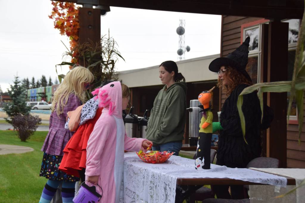 Trick-or-treaters visit a table at Kachemak Bay Campus for treats during Pioneer Avenue Trick or Treat on Friday, Oct. 31, 2025<ins>,</ins><ins> in Homer, </ins><ins>Alaska</ins>. (Delcenia Cosman/Homer News)