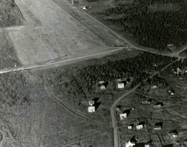 This 1946 Walter Smith aerial photograph is one of the latest known images to show the old quarters of the agricultural experiment station at Kenai. The log structure (seen directly above a more recent building just to the left of curving Overland Avenue), built in 1901, was razed in the early 1950s to make room for a modern garage/maintenance shop for the U.S. Fish & Wildlife Service.
