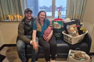 Aaron, Amanda and River Burdick are photographed at South Peninsula Hospital with gifts donated by local businesses and community members after River's arrival on Jan. 4, 2026, in Homer, Alaska. Photo provided by Derotha Ferraro