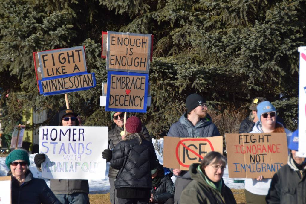 Community members carry signs protesting ongoing immigration raids and declaring solidarity with Minneapolis during the ICE OUT demonstration on Sunday, Feb. 1, 2026, at WKFL Park in Homer, Alaska. (Delcenia Cosman/Homer News)
