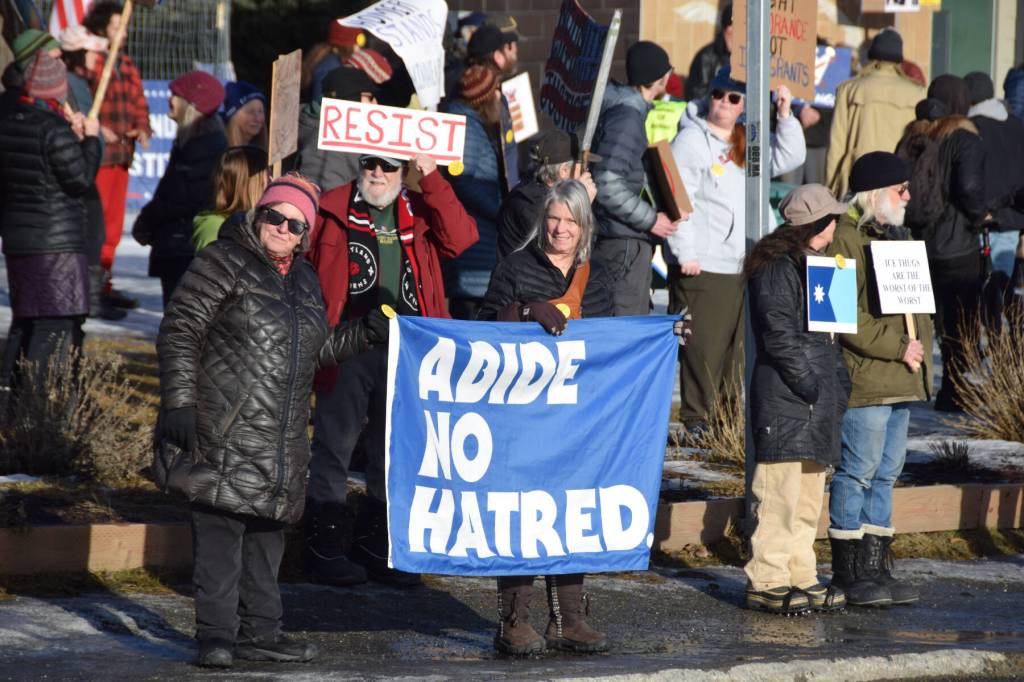 Protesters carry signs and flags during the ICE OUT demonstration on Sunday, Feb. 1, 2026, at WKFL Park in Homer, Alaska. (Delcenia Cosman/Homer News)