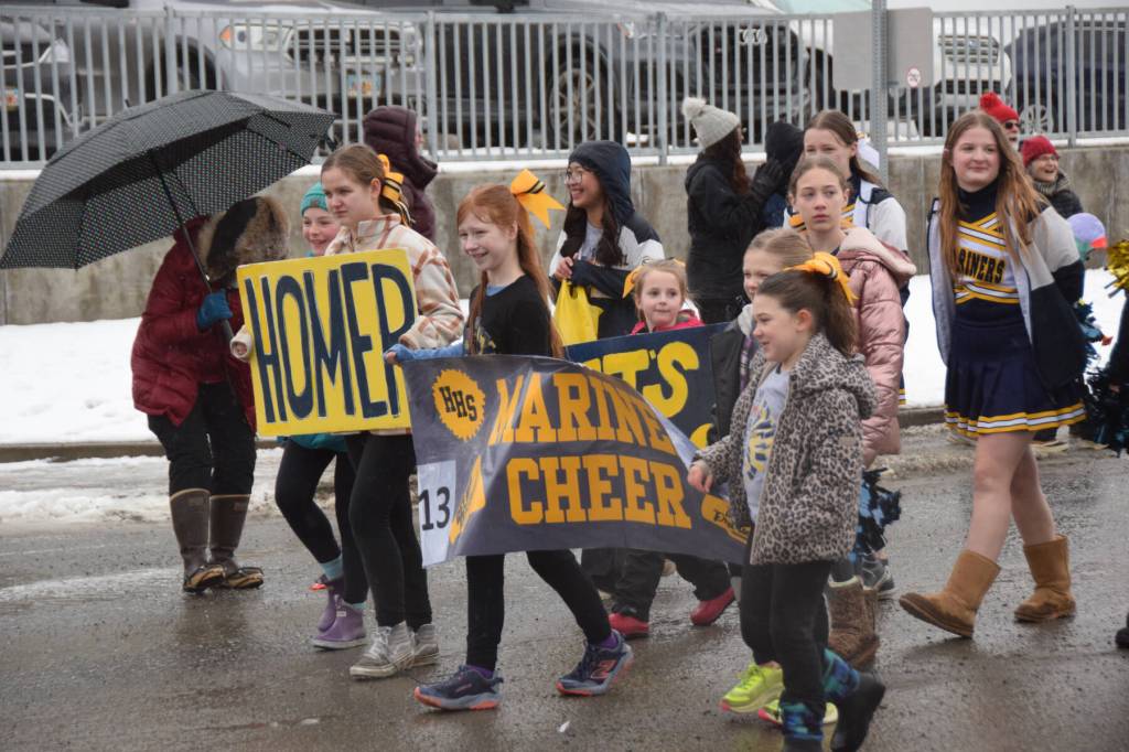 Cheerleaders of all ages with Homer Mariner Cheer walk down Pioneer Avenue during the Winter Carnival Parade on Saturday, Feb. 14, 2026, in Homer, Alaska. (Delcenia Cosman/Homer News)