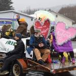 Grand Marshals David Brann (top left) and Robert Archibald (right) wave to spectators atop the Friends of Kachemak Bay State Parks float at the Winter Carnival Parade on Saturday, Feb. 14, 2026, in Homer, Alaska. (Delcenia Cosman/Homer News)