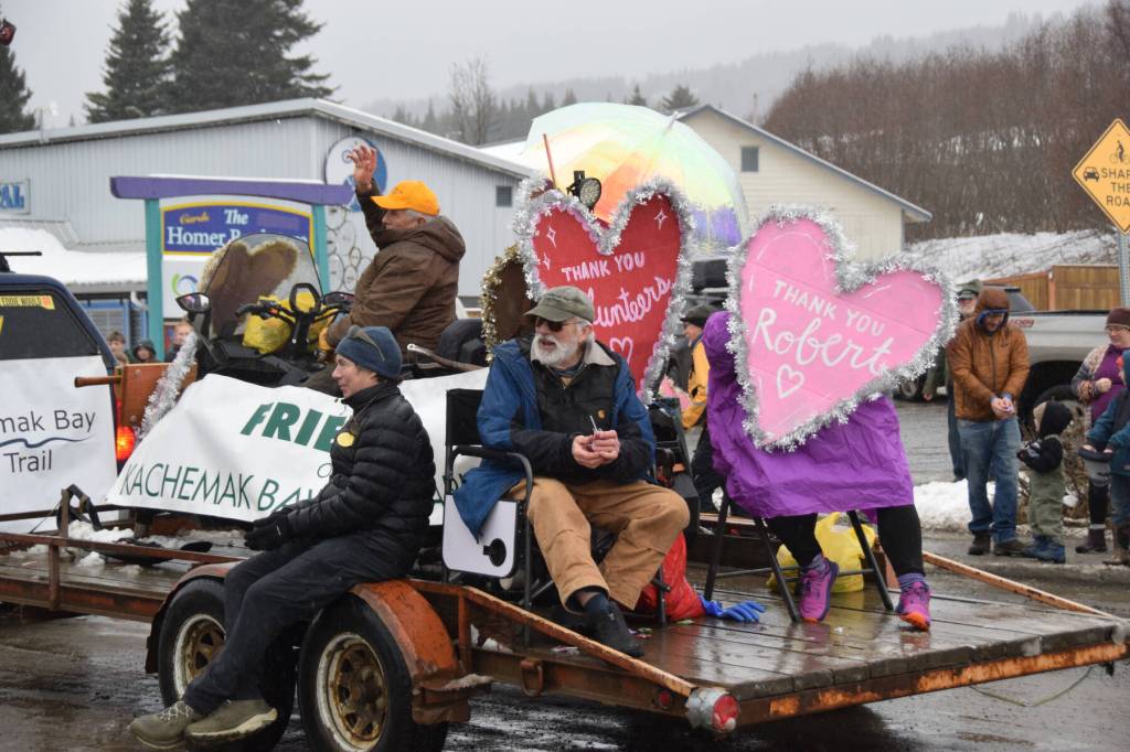 Grand Marshals David Brann (top left) and Robert Archibald (right) wave to spectators atop the Friends of Kachemak Bay State Parks float at the Winter Carnival Parade on Saturday, Feb. 14, 2026, in Homer, Alaska. (Delcenia Cosman/Homer News)